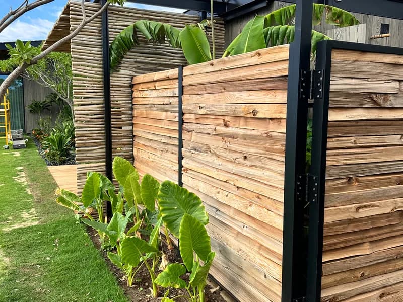 Custom metal and wood privacy fence with tropical landscaping, Maui